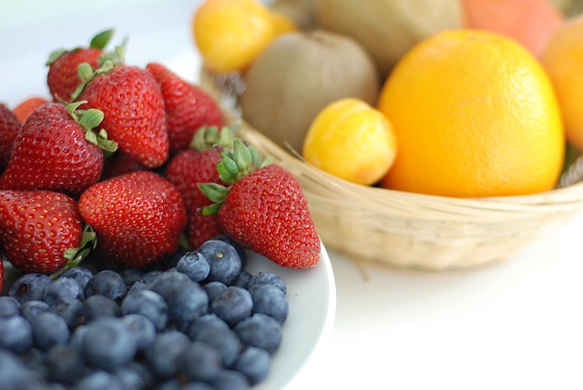 Zwei Schalen vol mit Früchten, zum Beispiel Erdbeeren und Orangen