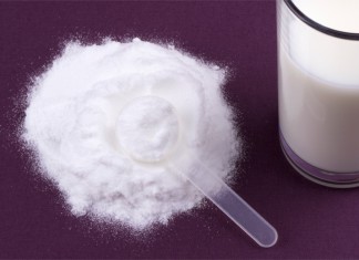 Kreatin in Pulverform mit einem Plastiklöffel