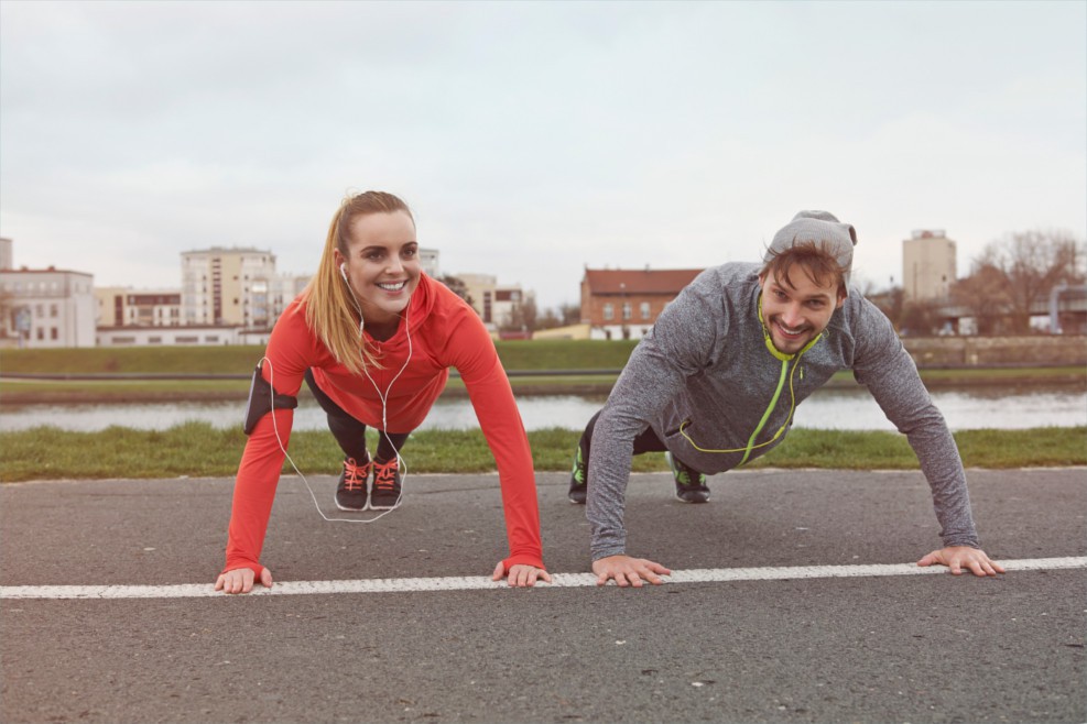 Eine Frau und ihr Trainingspartner machen zusammen Liegestütze