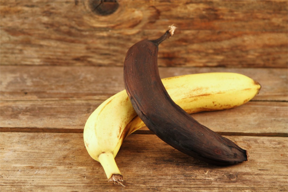 Eine frische und eine schwarze Banane