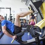 Sportler im Fitnesscenter trainiert an der Beinpresse