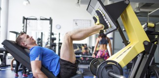 Sportler im Fitnesscenter trainiert an der Beinpresse