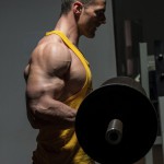 Sportler trainiert Oberarmcurls mit der Langhantel