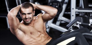Sportler trainiert seine seitlichen Bauchmuskeln mit Cross-Crunches