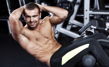Sportler trainiert seine seitlichen Bauchmuskeln mit Cross-Crunches