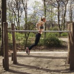 Sportlerin trainiert Dips zur Brust auf einem Barren