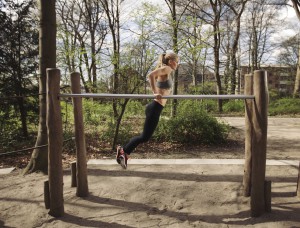 Sportlerin trainiert Dips zur Brust auf einem Barren