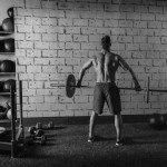 Sportler trainiert im Gym mit einer Langhantel