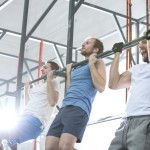 Sportler trainieren Klimmzüge mit engem Untergriff