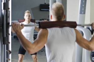 Sportler trainiert an der Multipresse Kniebeugen