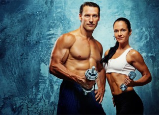 Ein trainierter Mann und eine fitte Frau jeweils mit einer Hantel in der Hand