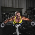 Sportler trainiert Reverse Butterfly mit der Kurzhantel