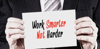 Ein Manager hält ein Schilder mit der Aufschrift "Work Smarter not Harder"