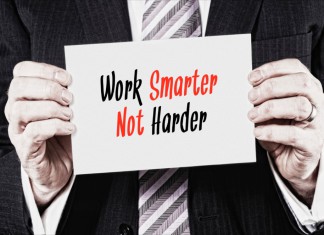 Ein Manager hält ein Schilder mit der Aufschrift "Work Smarter not Harder"