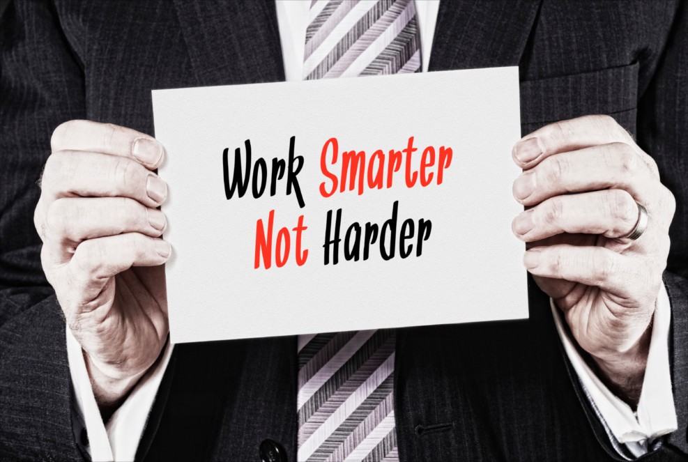 Ein Manager hält ein Schilder mit der Aufschrift "Work Smarter not Harder"