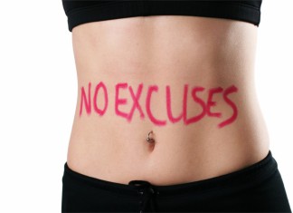 Der schlanke Bauch einer Frau mit der Aufschrift "NO EXCUSES"