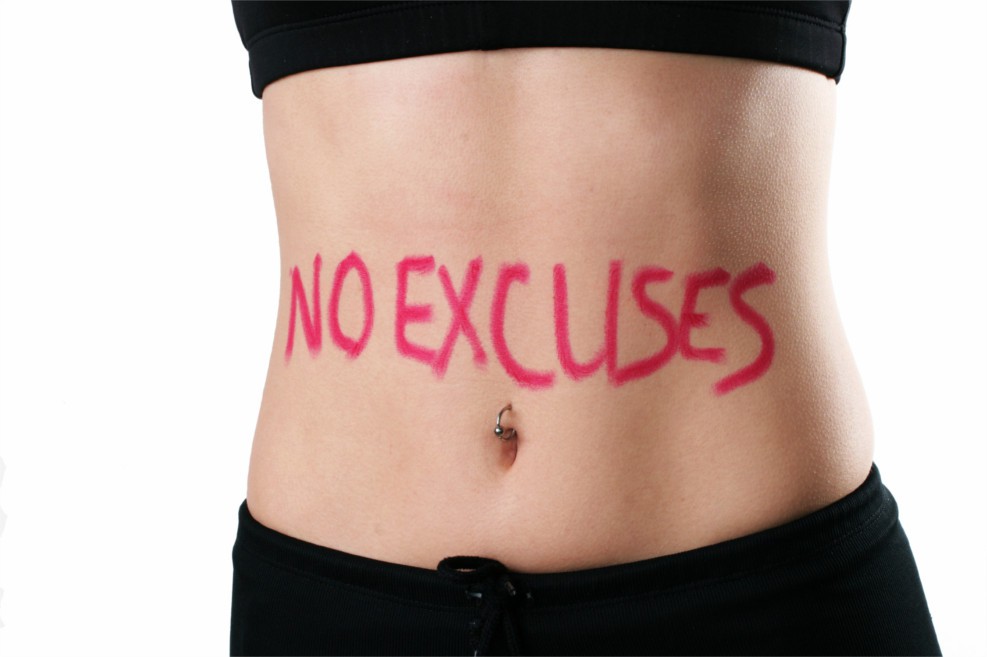 Der schlanke Bauch einer Frau mit der Aufschrift "NO EXCUSES"