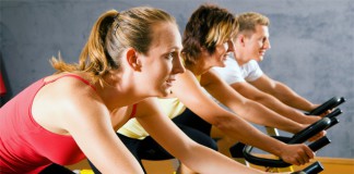 Drei Sportler beim Spinning im Fitness-Studio