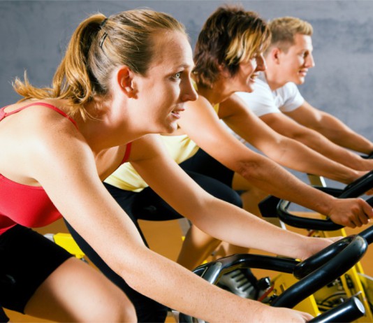 Drei Sportler beim Spinning im Fitness-Studio