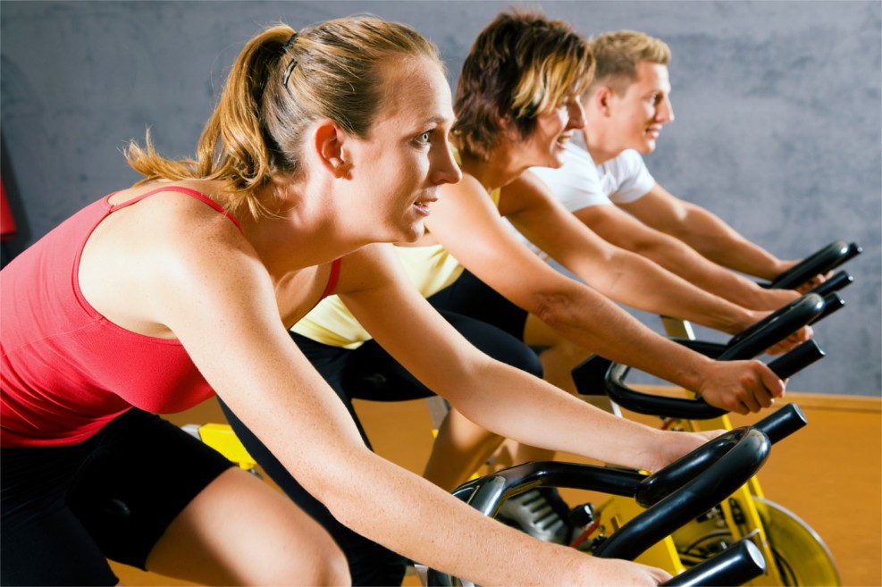 Drei Sportler beim Spinning im Fitness-Studio