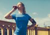 Eine Frau im sportlichen Outfit trinkt einen Eiweißshake